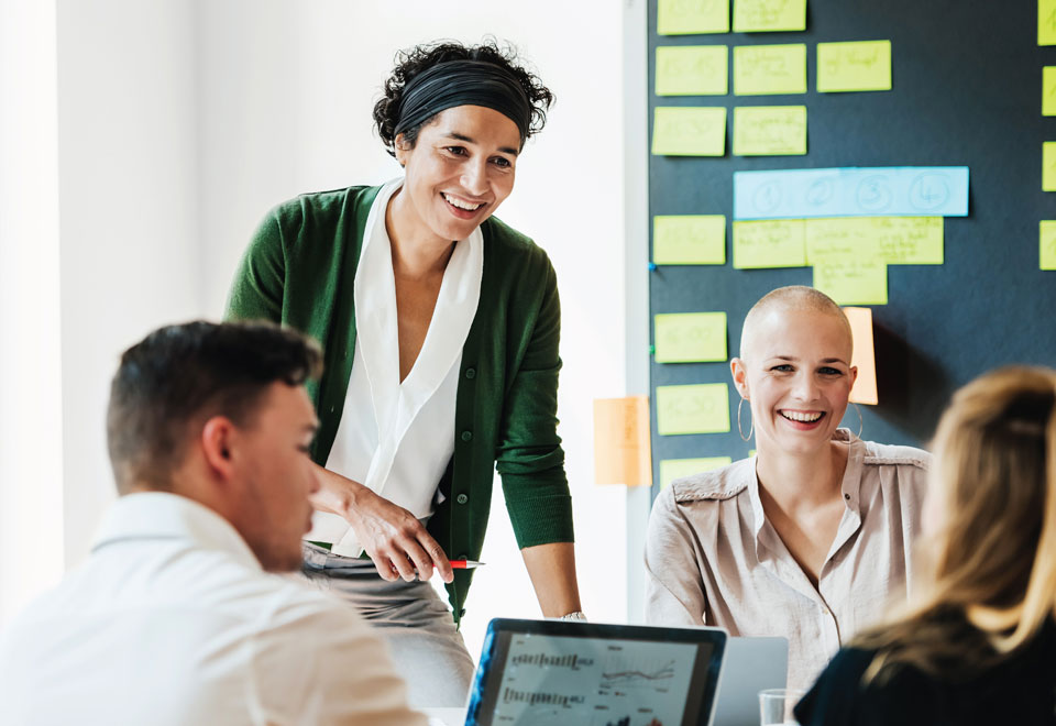Group of Securian Canada colleagues smile together in an office during a meeting.