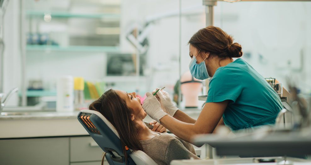 A dentist examines a patient in a dental clinic.