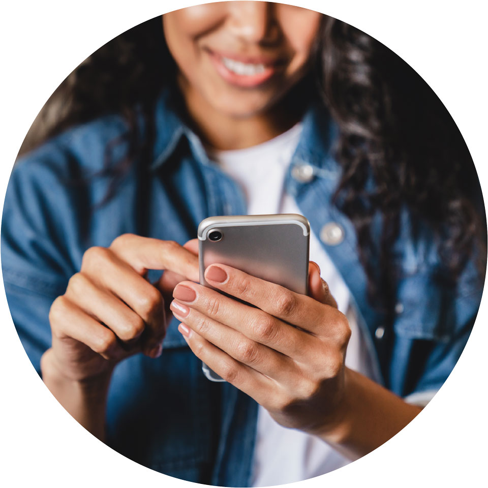 Person smiles while holding a smartphone in their hands.